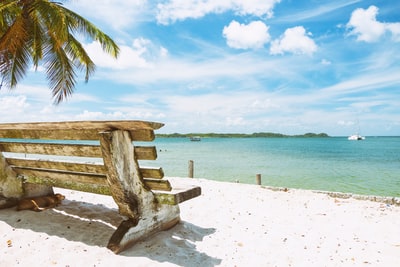 White brown wooden bench on the beach
